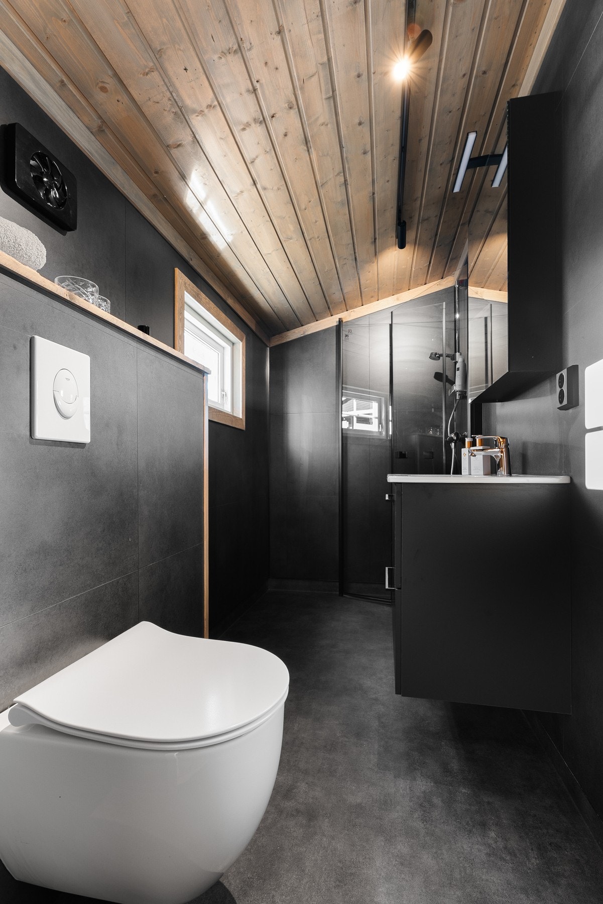 Nyetablert baderom med vegghengt toalett, innredning med servant og dushjørne med glassdører Galleribilde