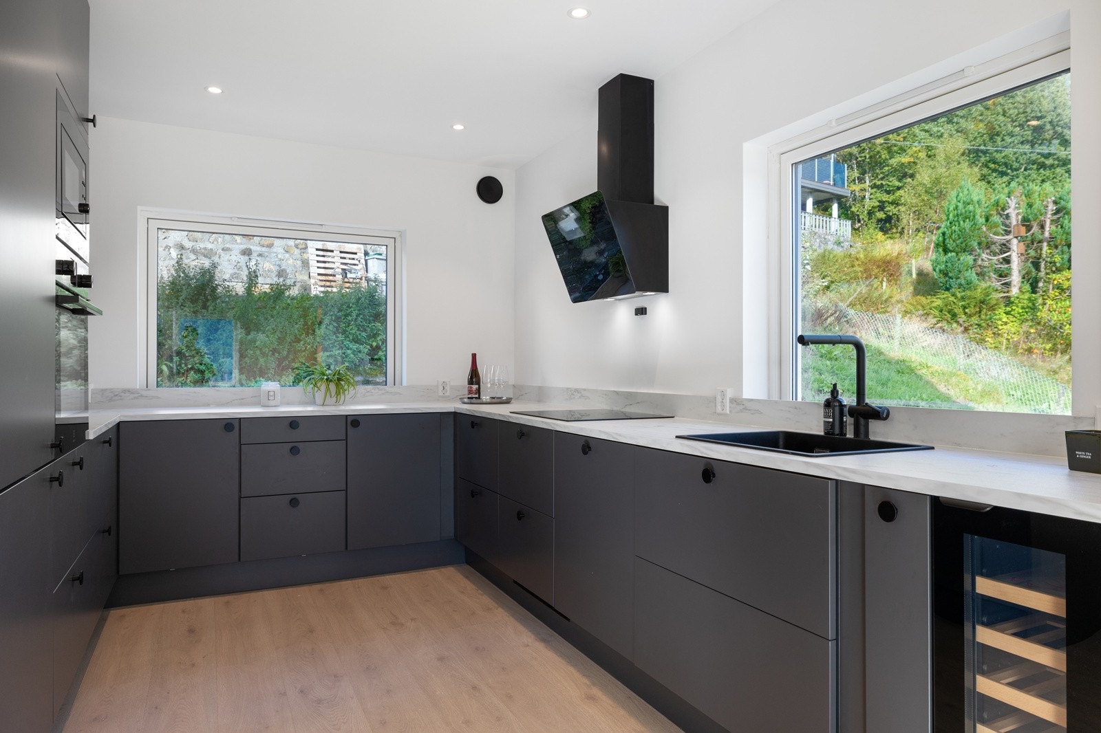 Påkostet kjøkkeninnredningen med glatte fronter og laminert benkeplate med kjøkkenvask. Galleribilde