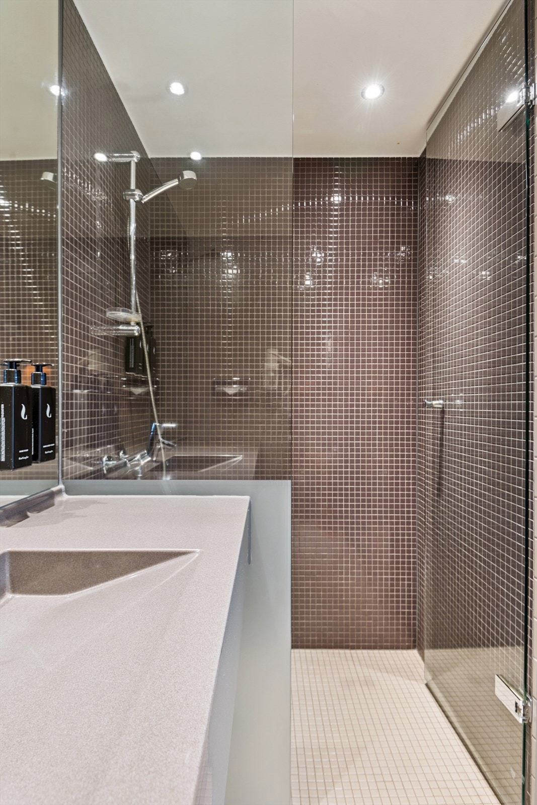 Mosaikkfliser i dusjsonen og heldekkende servant gir et delikat uttrykk. Galleribilde