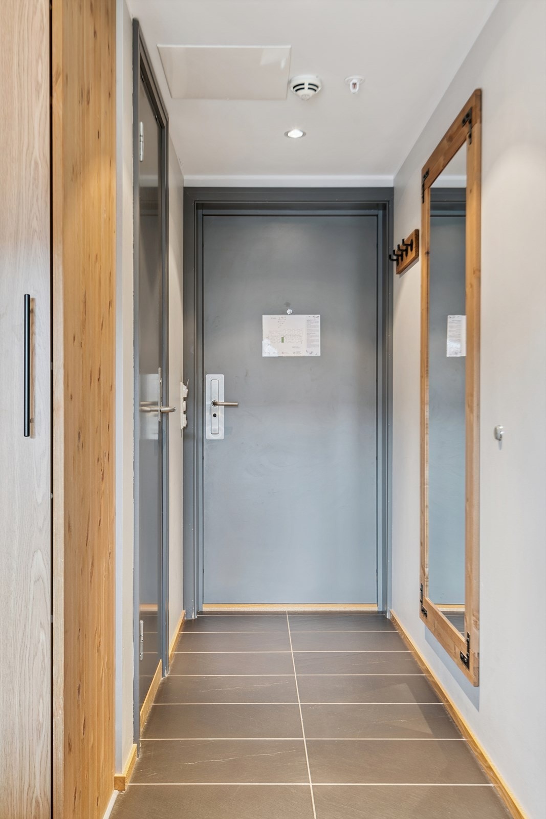 Velkommen inn i en praktisk entré med flislagt gulv og plass til å henge fra seg yttertøy. Galleribilde