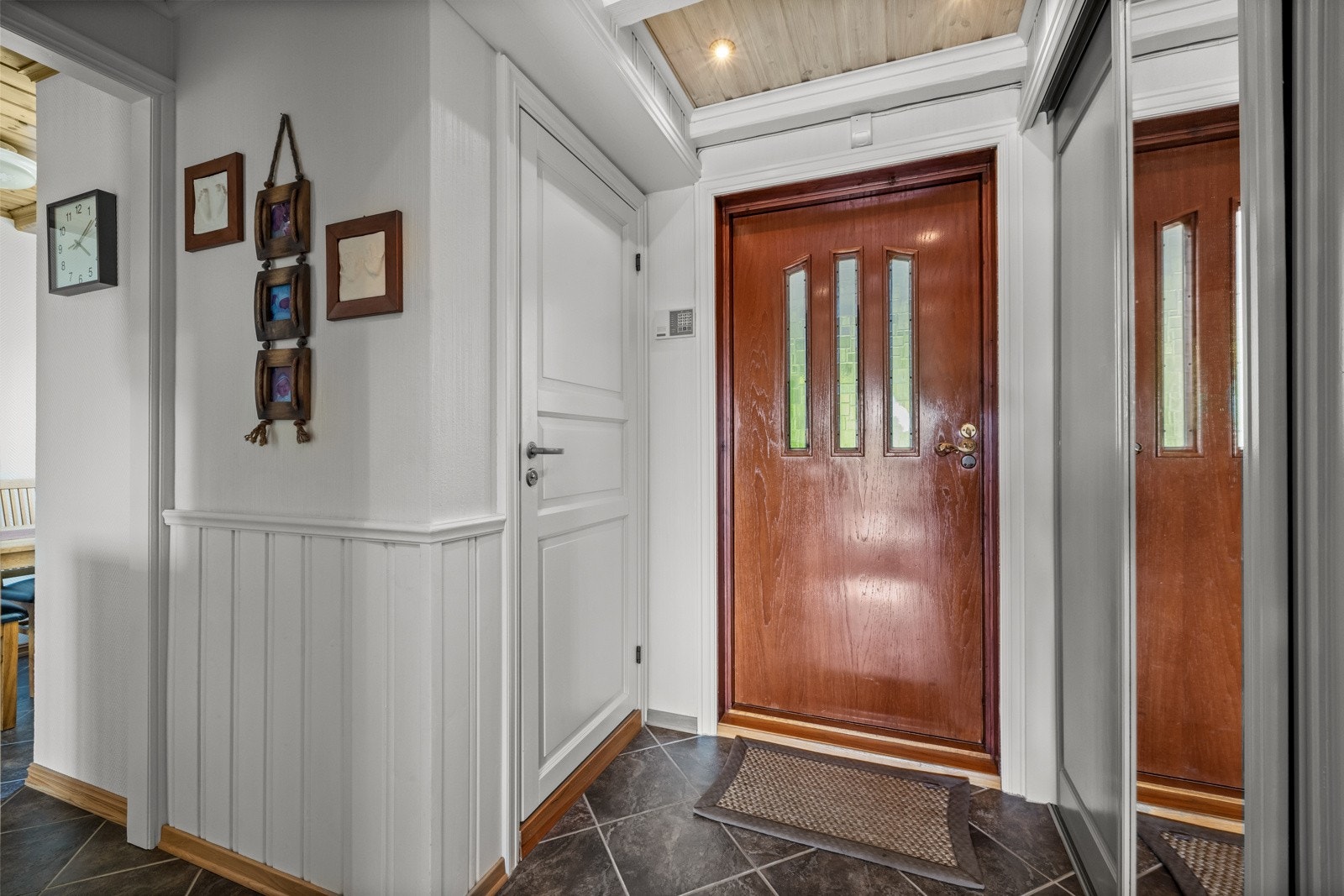 Flislagt entré med skyvedørsgarderobe og direkte tilgang inn til toalettet. Galleribilde