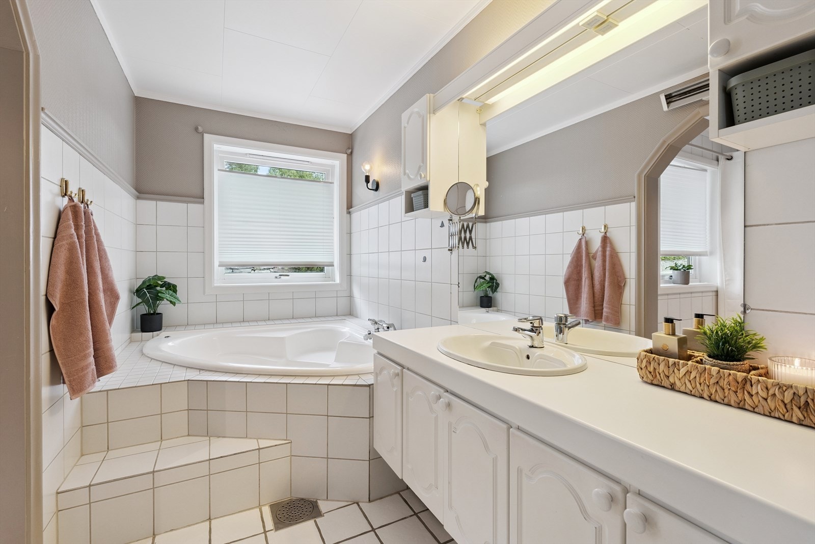 Hovedbadet er flislagt med varmekabler i gulv, har flislagt dusjnisje og innfliset hjørnebadekar. Her er det også større baderomsinnredning og gulvmontert toalett. Galleribilde