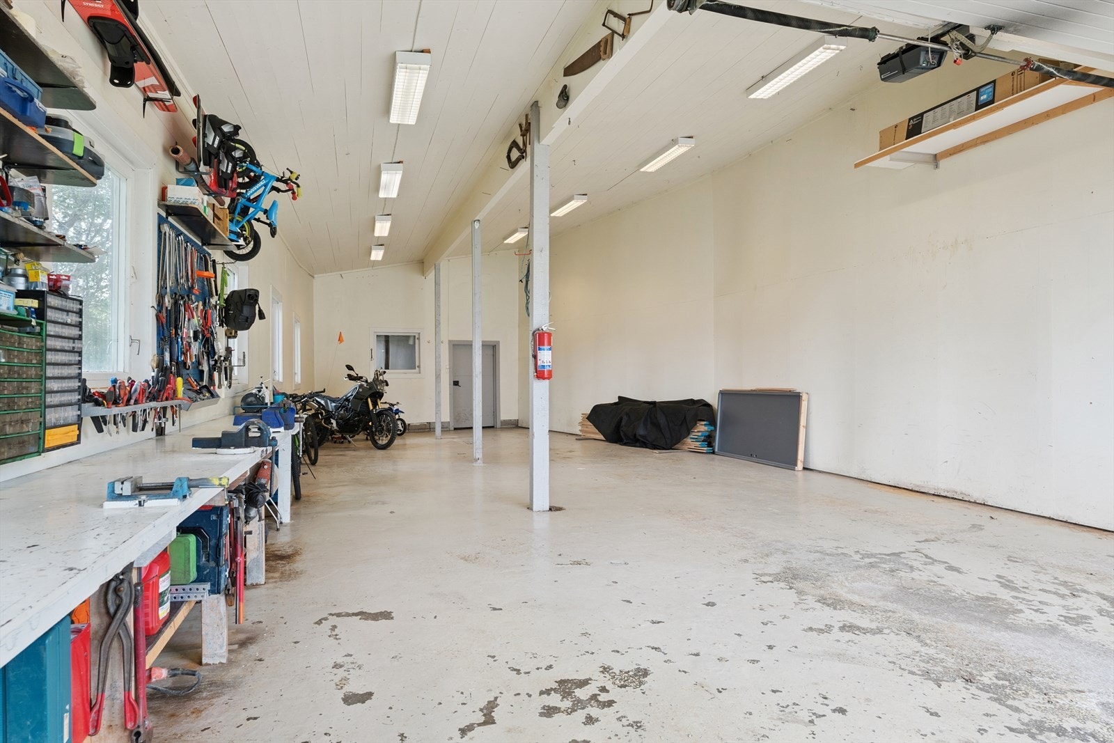 Med eiendommen følger også et kombinert garasje- og verkstedbygg med mulighet for ekstra garasjeplass, hobbyverksted m.m. Bygget har større leddport, og to vanlige dører. Galleribilde