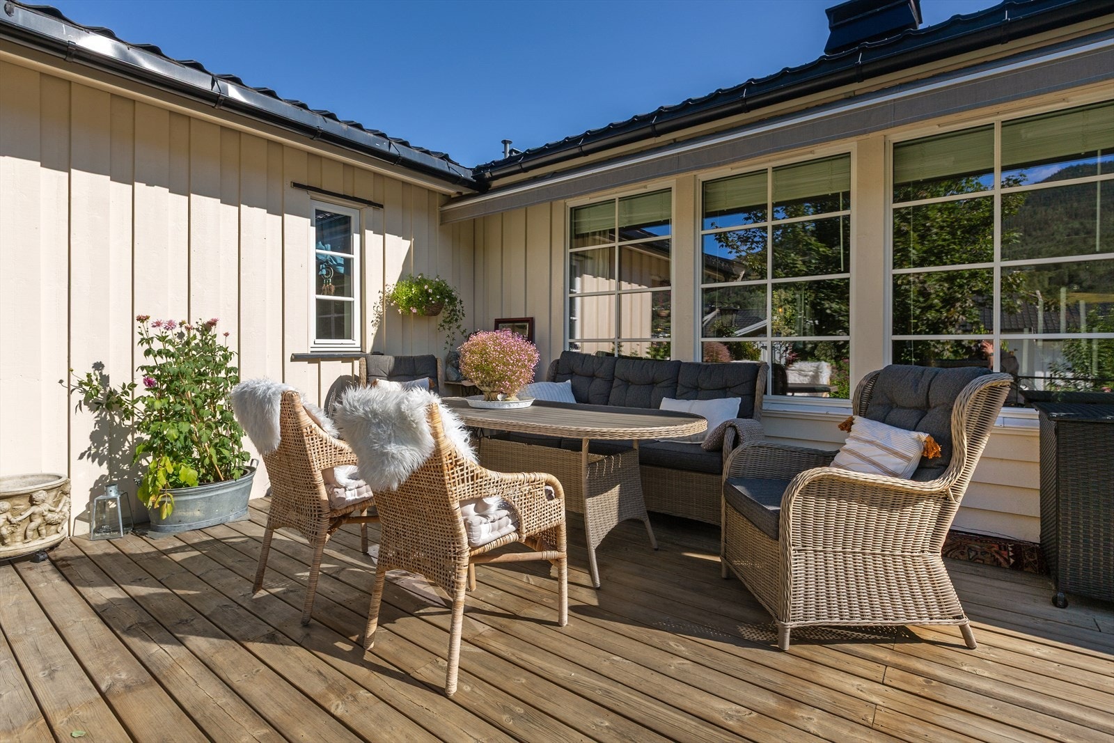 Her er det stor, solrik terrasse og en pent opparbeidet tomt med vakre blomster og frodig beplantning. Det er også eget lysthus og en liten, steinsatt dam. Galleribilde