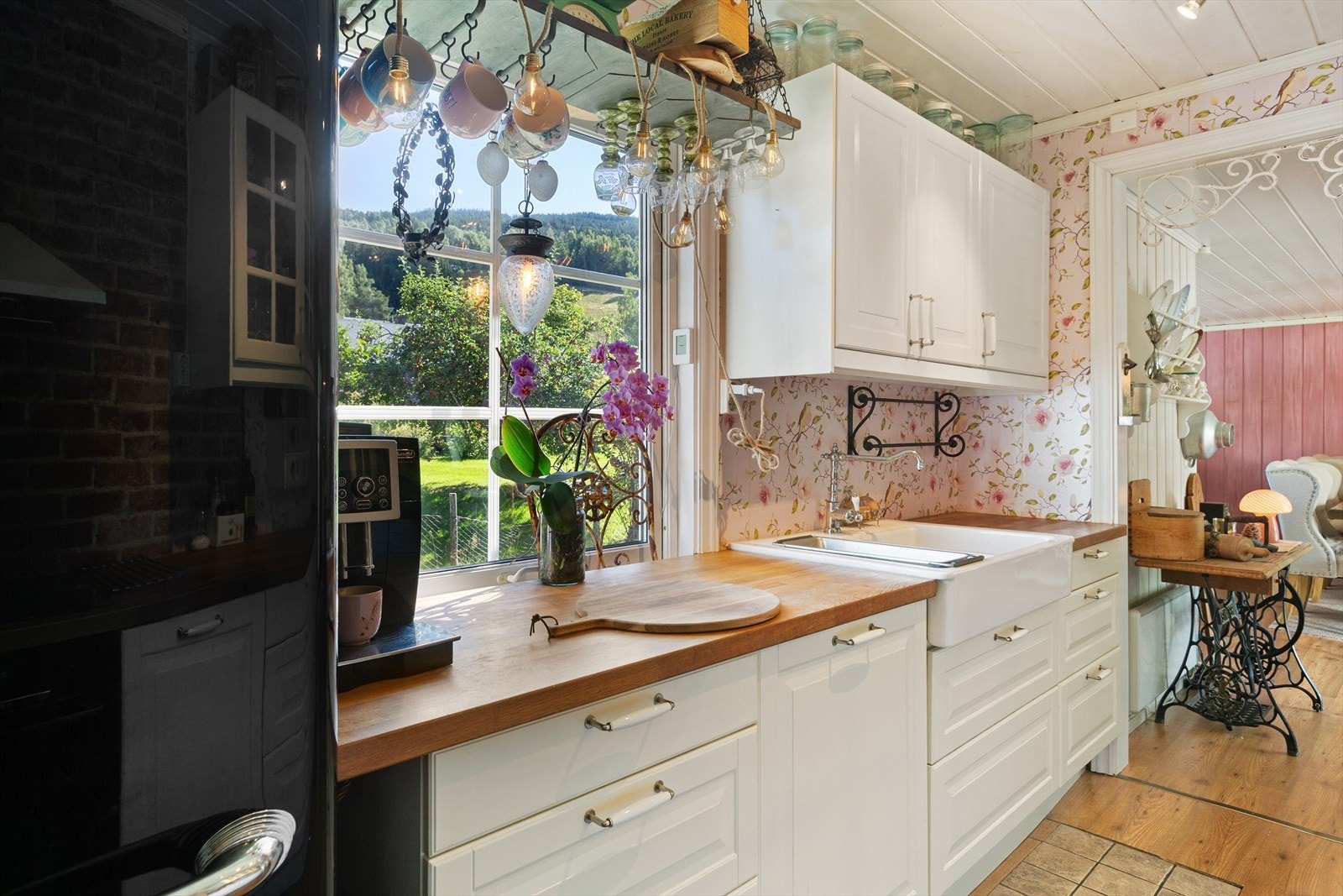 Kjøkkeninnredningen har malte og profilerte fronter, samt to overskap med glassdører. Kjøkkenet har heltre benkeplate, stilig porselenskum og ettgreps blandebatteri. Galleribilde