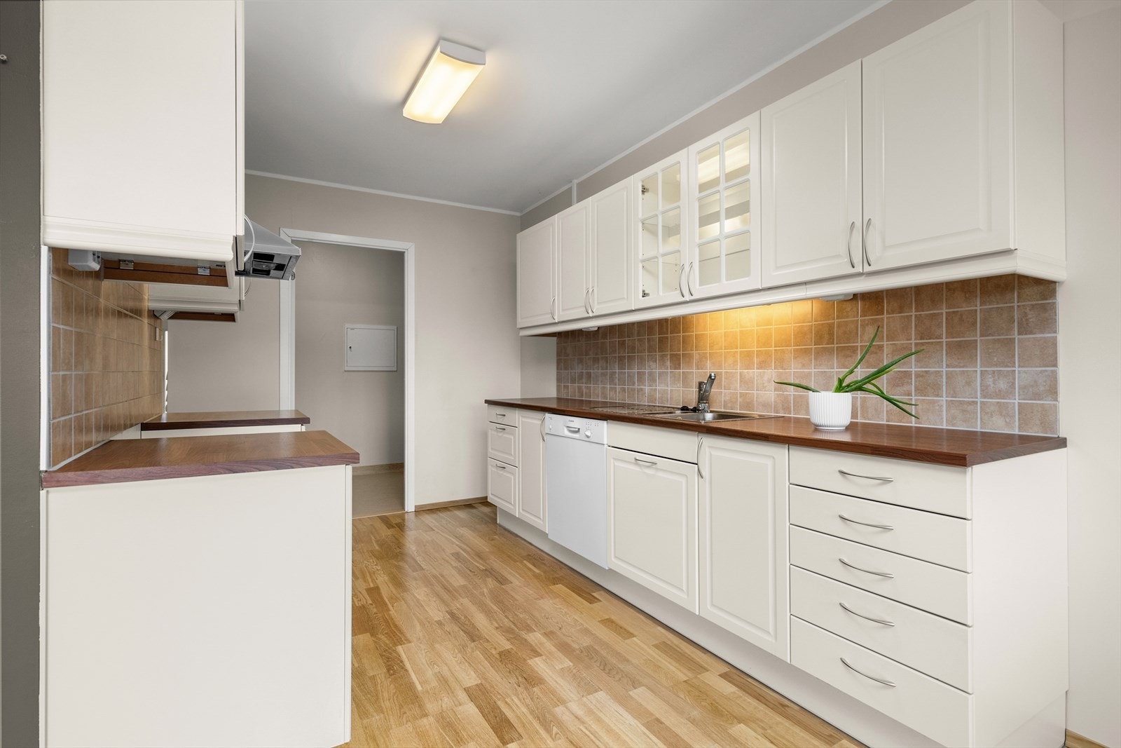 Flislagt veggfelt over kjøkkenbenken gir en praktisk arbeidsflate. Galleribilde