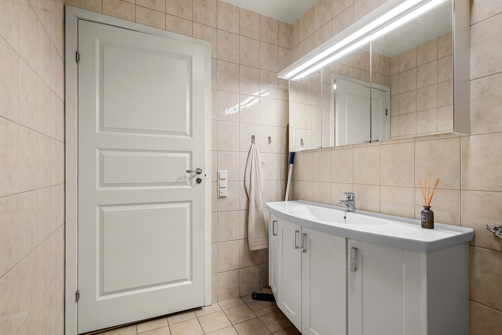 Baderomsinnredning med nedfelt servant og speilskap gir praktisk oppbevaring. Galleribilde