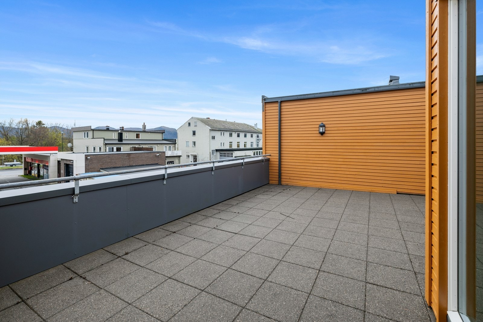 Terrassen har en åpen og luftig plassering med utsikt mot nærliggende bygninger. Galleribilde