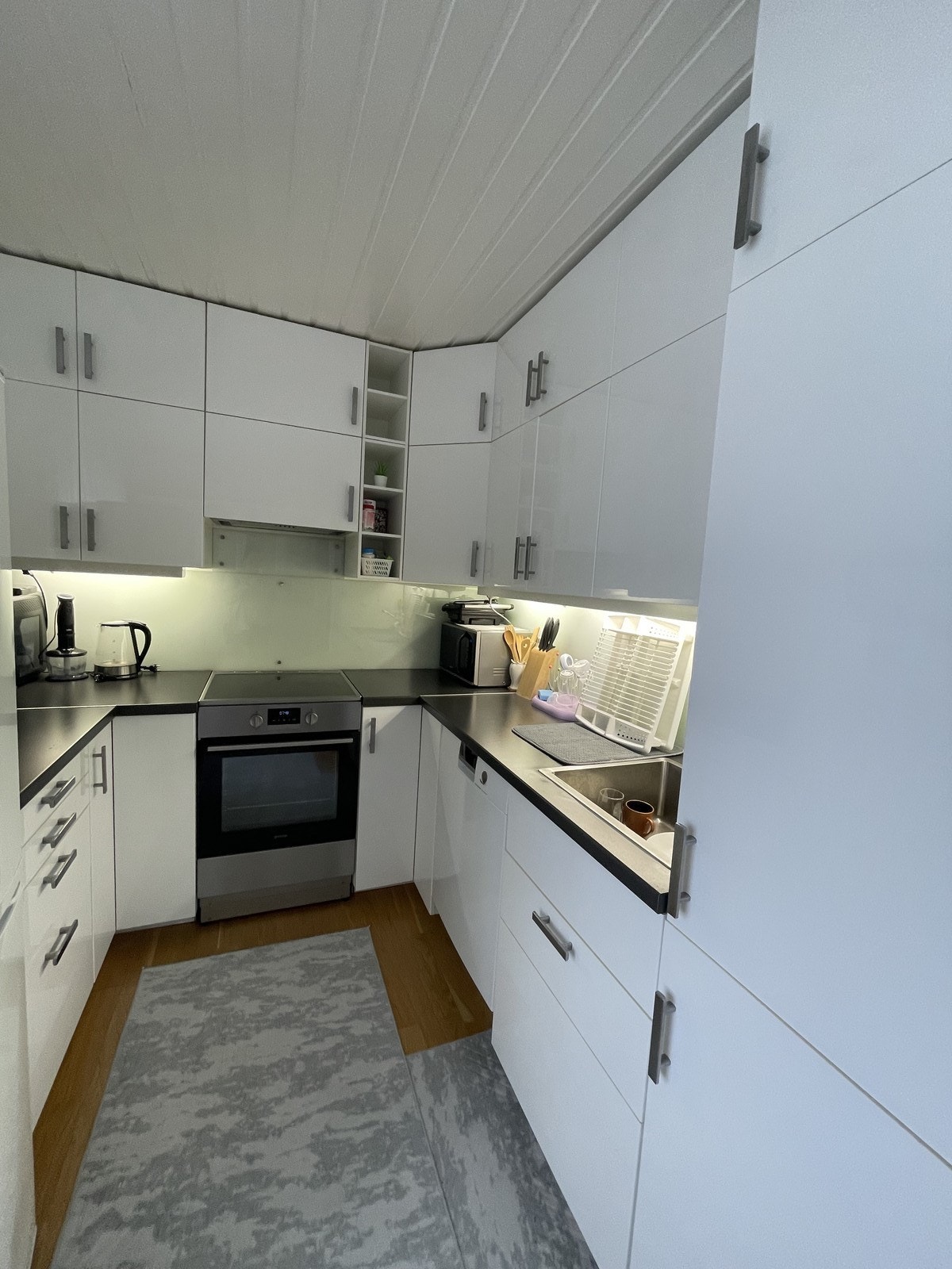 Mye oppbevaringsplass på kjøkken. Kombiskap, komfyr med koketopp og oppvaskmaskin føgler med. Galleribilde