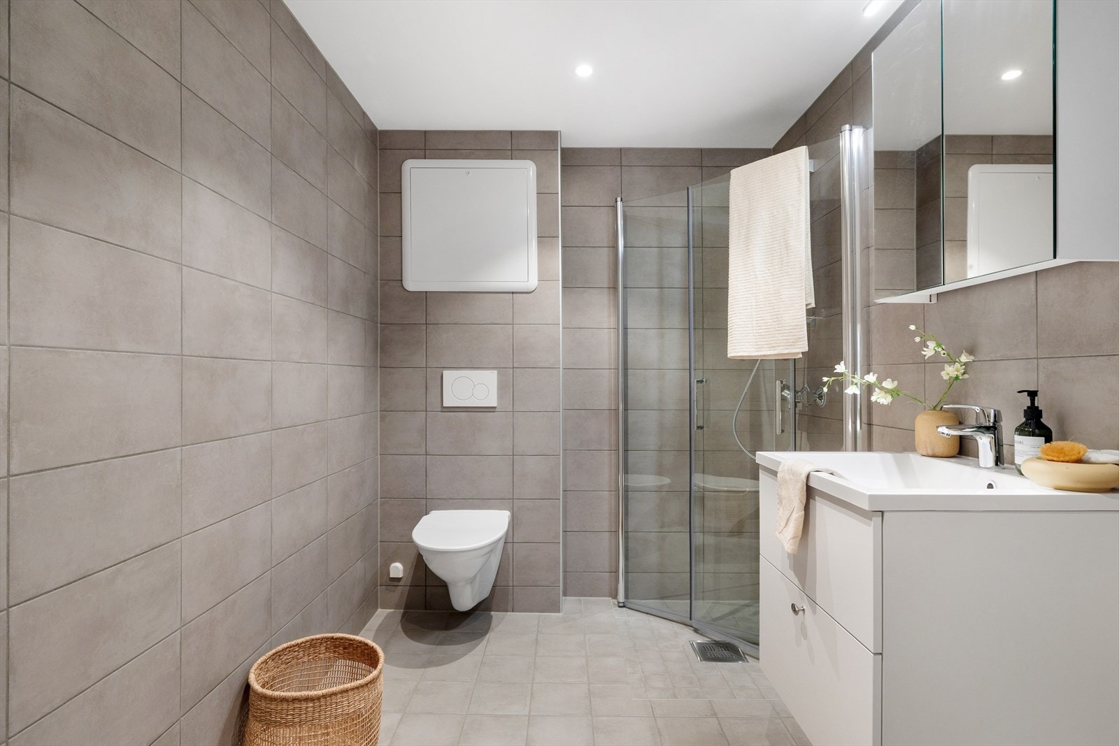 Lekkert helfliset baderom med møblement, speil og belysning Galleribilde