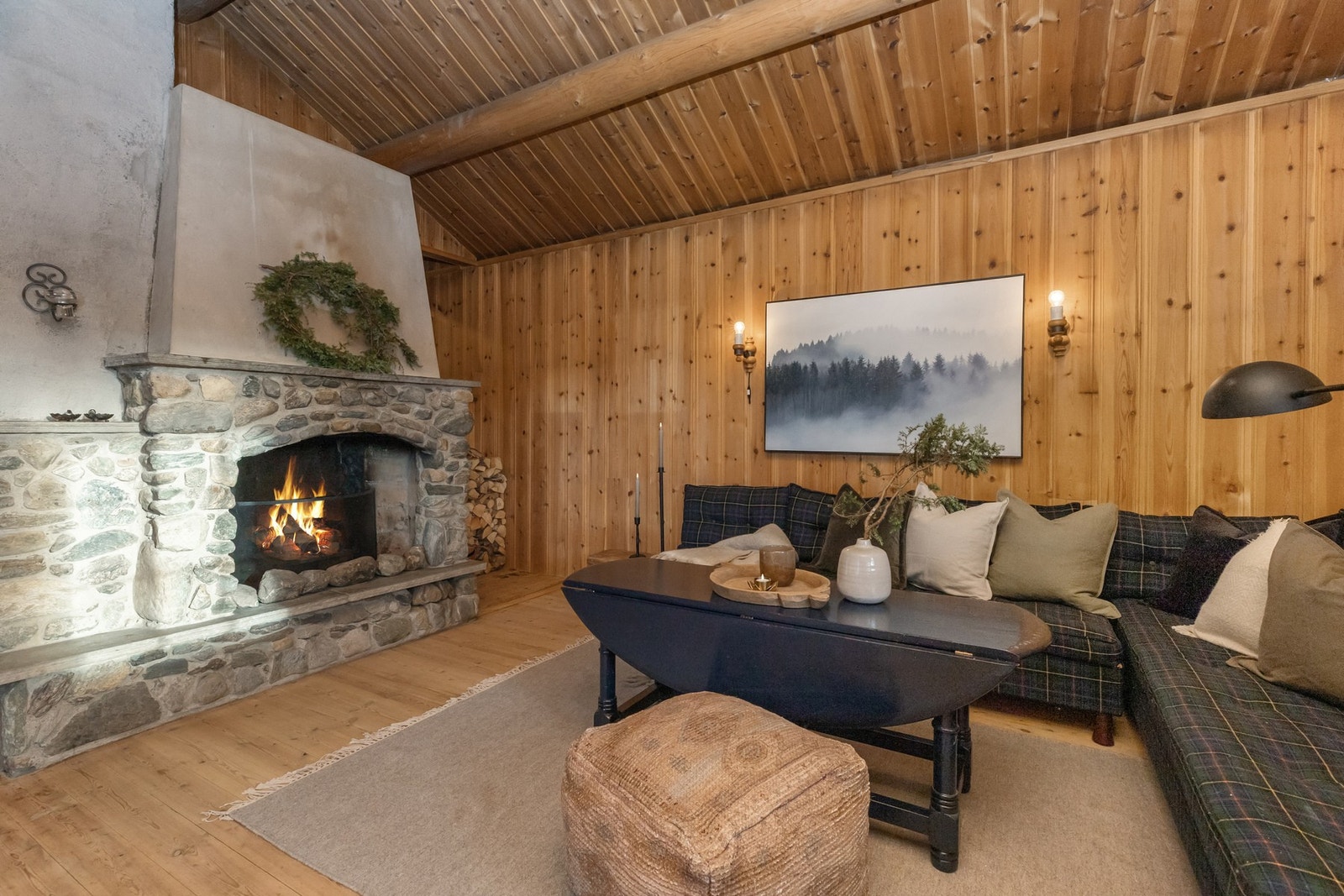 Stuen har generøs takhøyde og synlige tømmeråser som skaper en luftig og harmonisk romfølelse Galleribilde