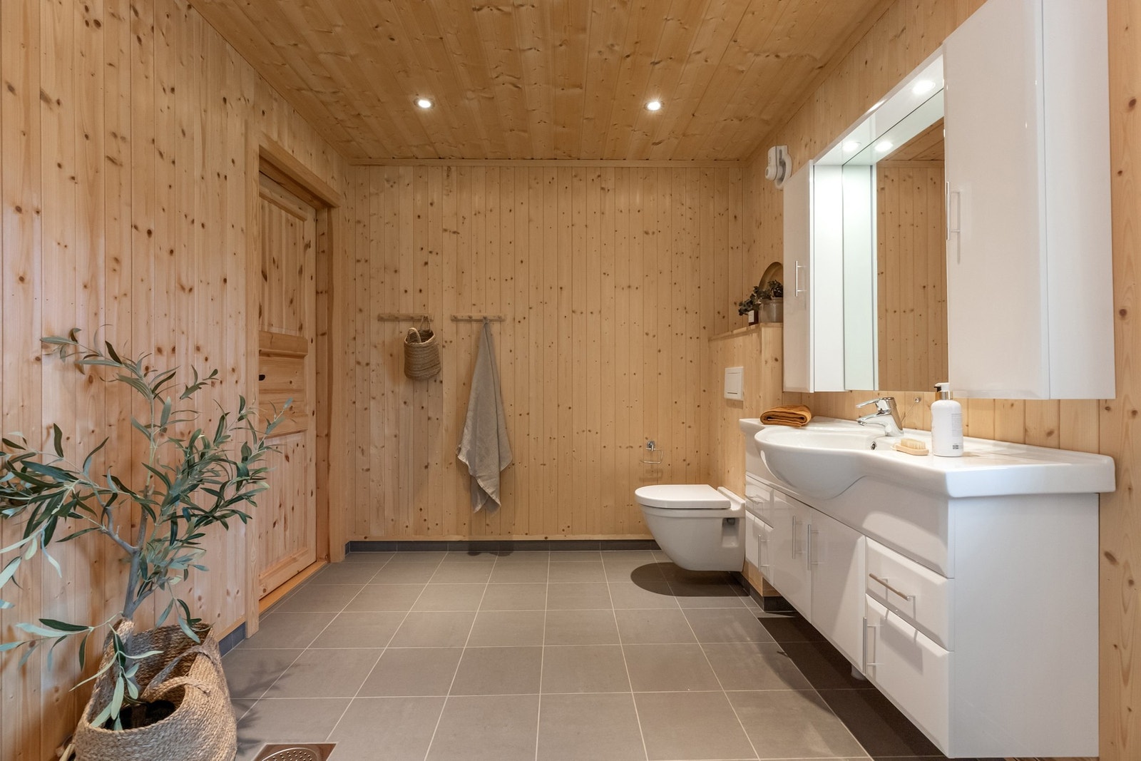 To flotte bad med flislagte gulv og panel på veggene Galleribilde