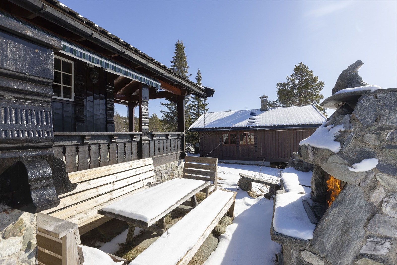 Hytta har gode uteområder med natursteinsbelagt utekjøkken Galleribilde