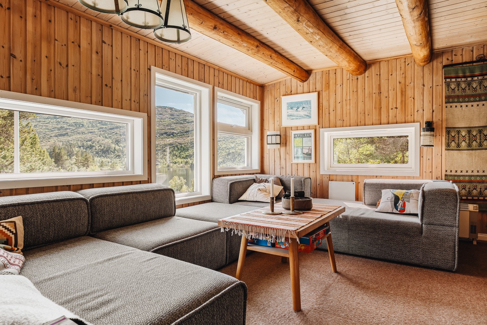 Her er det teppe på gulvet, trepanel på vegger og tak og god plass til en stor og sosial sofagruppe. Galleribilde