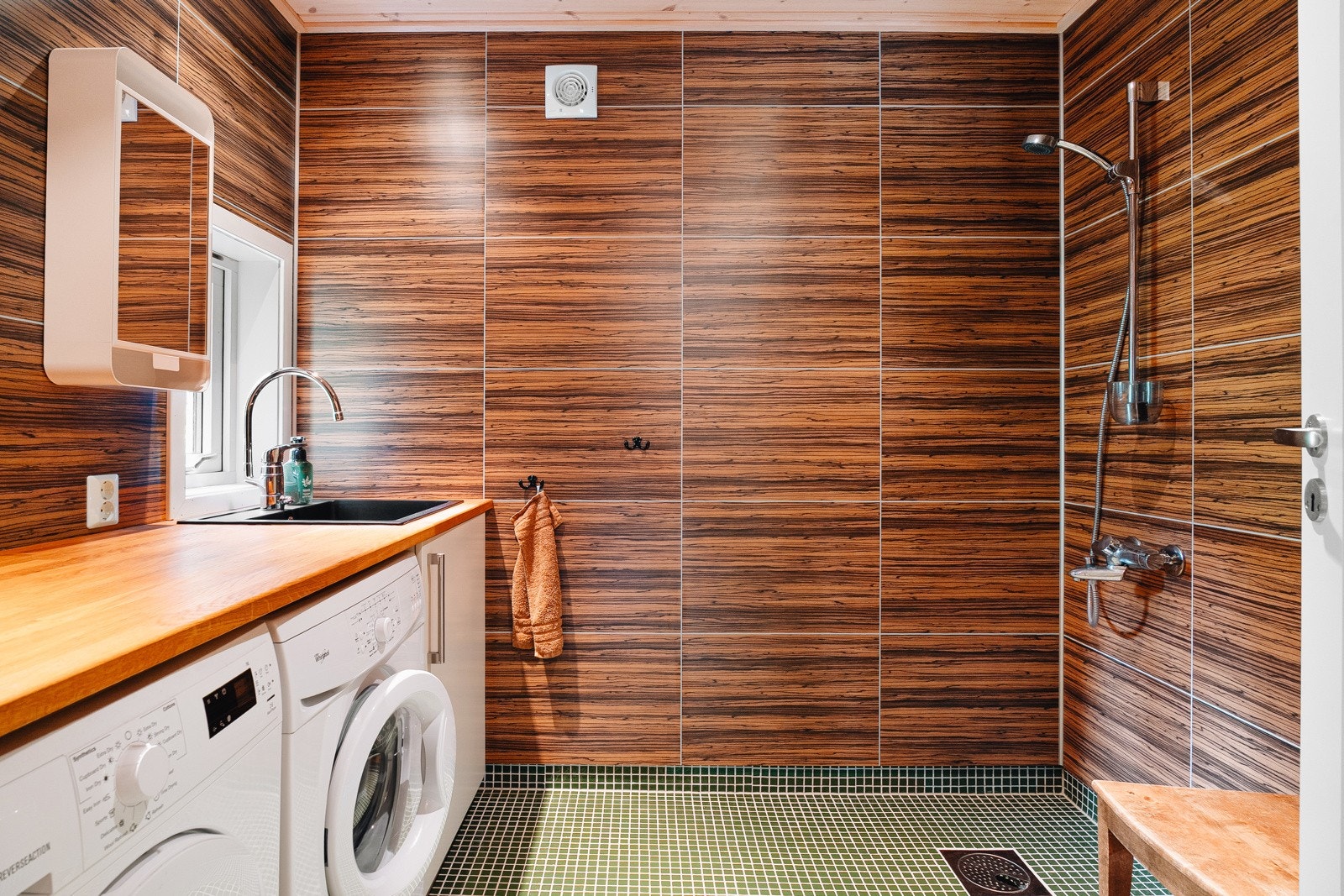 Hyttens praktiske bad på 5,4 m², fra ca. 2011, har keramiske fliser på gulv, baderomsplater på vegger og panel i himling. Galleribilde