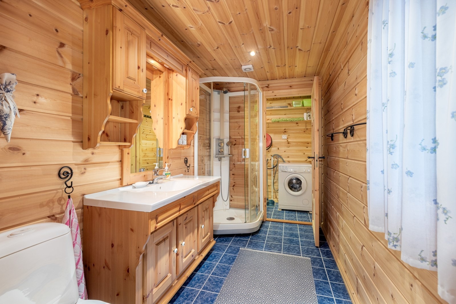 Badet er innredet med toalett, dusjkabinett og servantinnredning med underskap, overskap og speil. Galleribilde