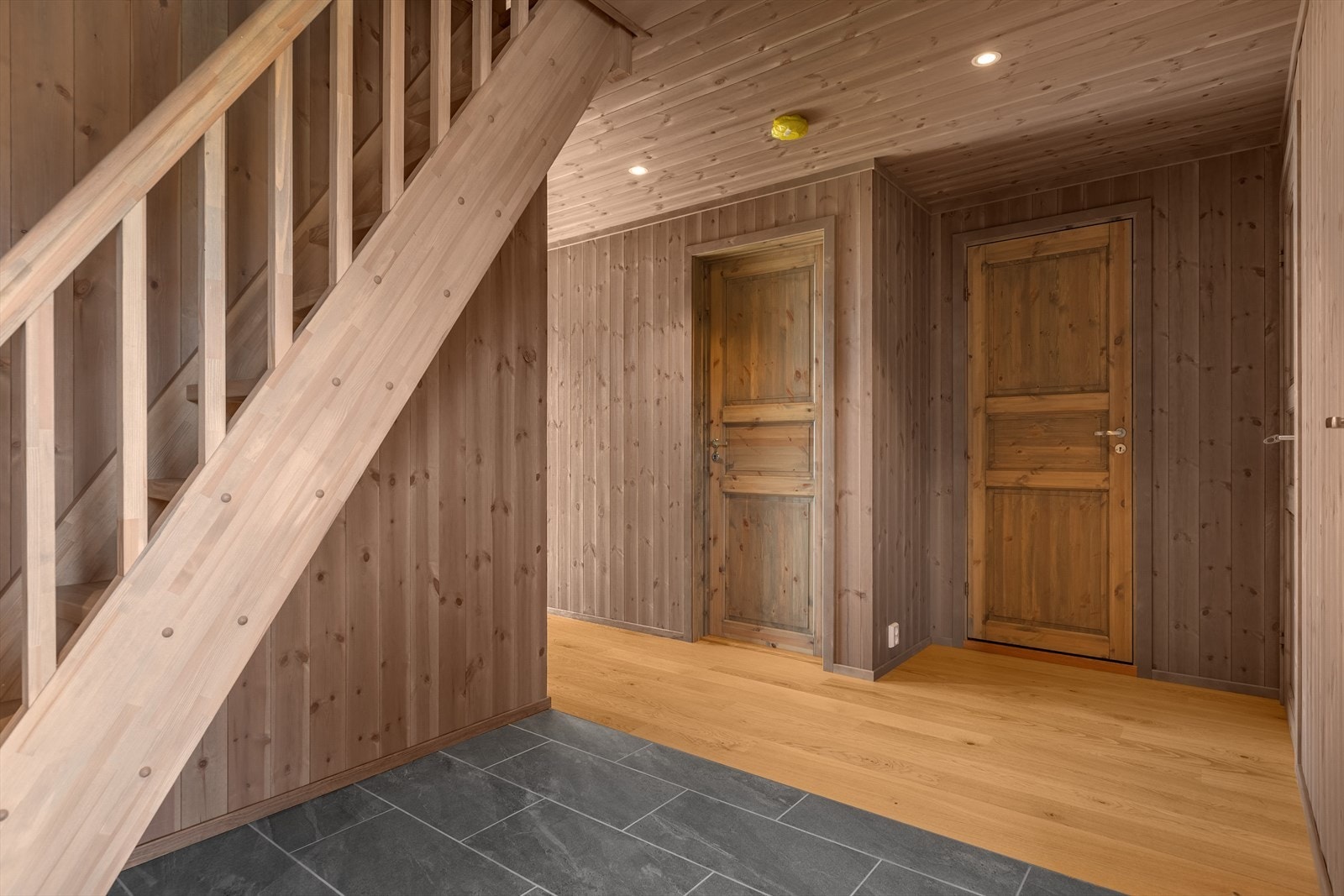 I den romslige gangen er det god garderobeplass og pent, flislagt gulv og varmekabler i deler av rommet. Galleribilde