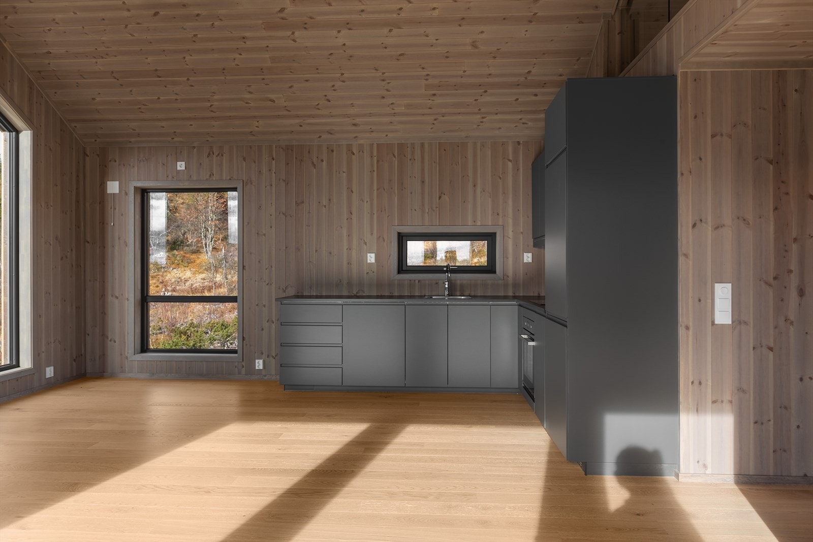 Hyttas stilrene kjøkkeninnredning er fra serien Voxtorp hos Ikea. Den har mørke, glatte fronter og godt med skap- og benkeplass. Galleribilde