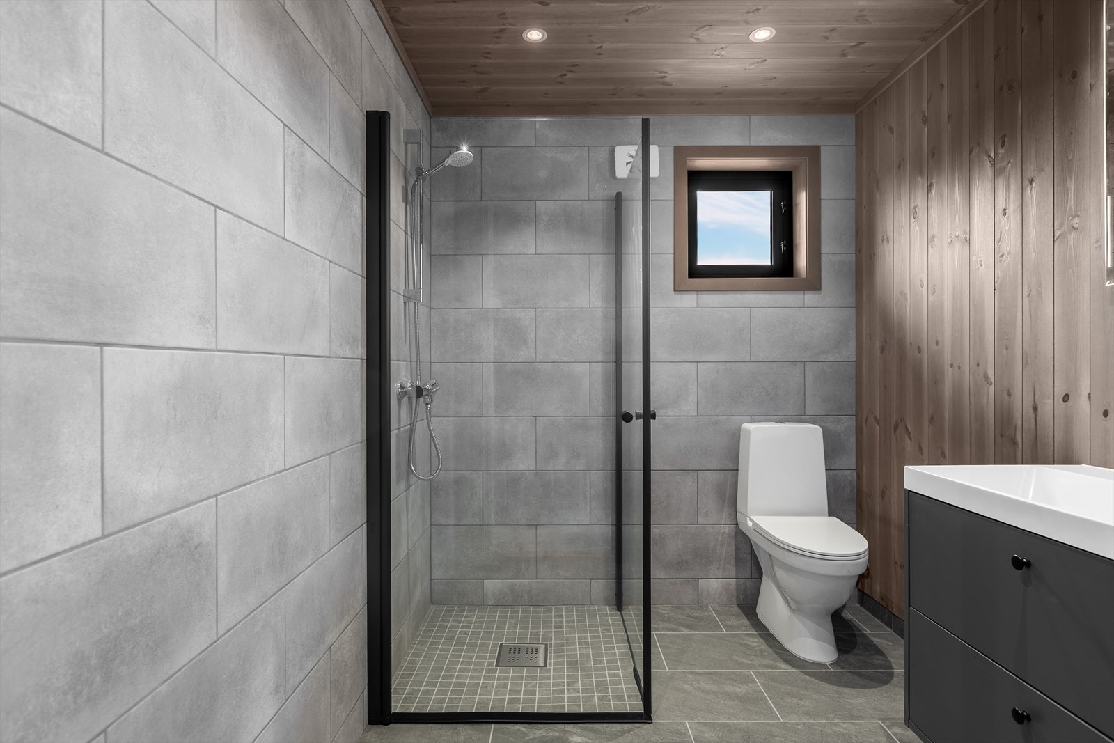 Hytta har et delikat bad med fliser og varmekabler i gulvet. To av veggene er flislagte, mens de øvrige har panel. Galleribilde