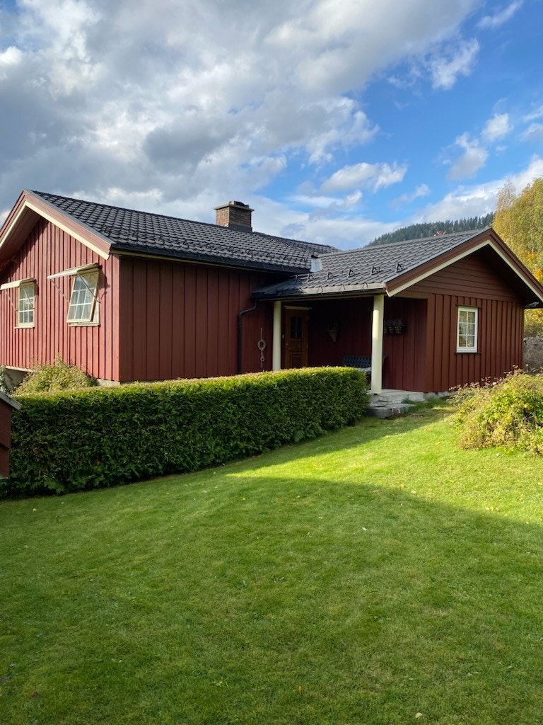 Nær boligen overbygd inngangsparti er det hekk, fin plen og beplantning. (Selgers foto) Galleribilde