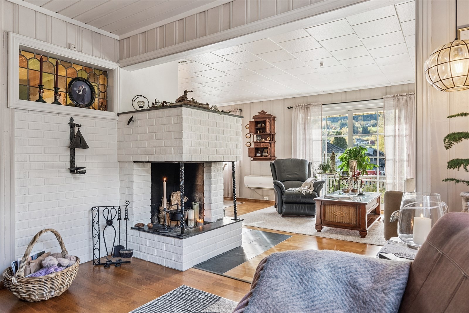 Det er fin plass til flere sittegrupper, og en åpen, hvitmalt peis gir en hyggelig stemning til stua. Galleribilde