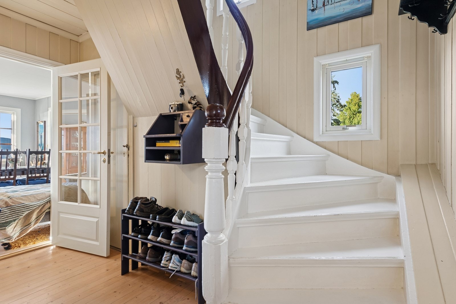 Trappen i trekonstruksjon har en elegant sving og leder opp til loftsetasjen. Galleribilde