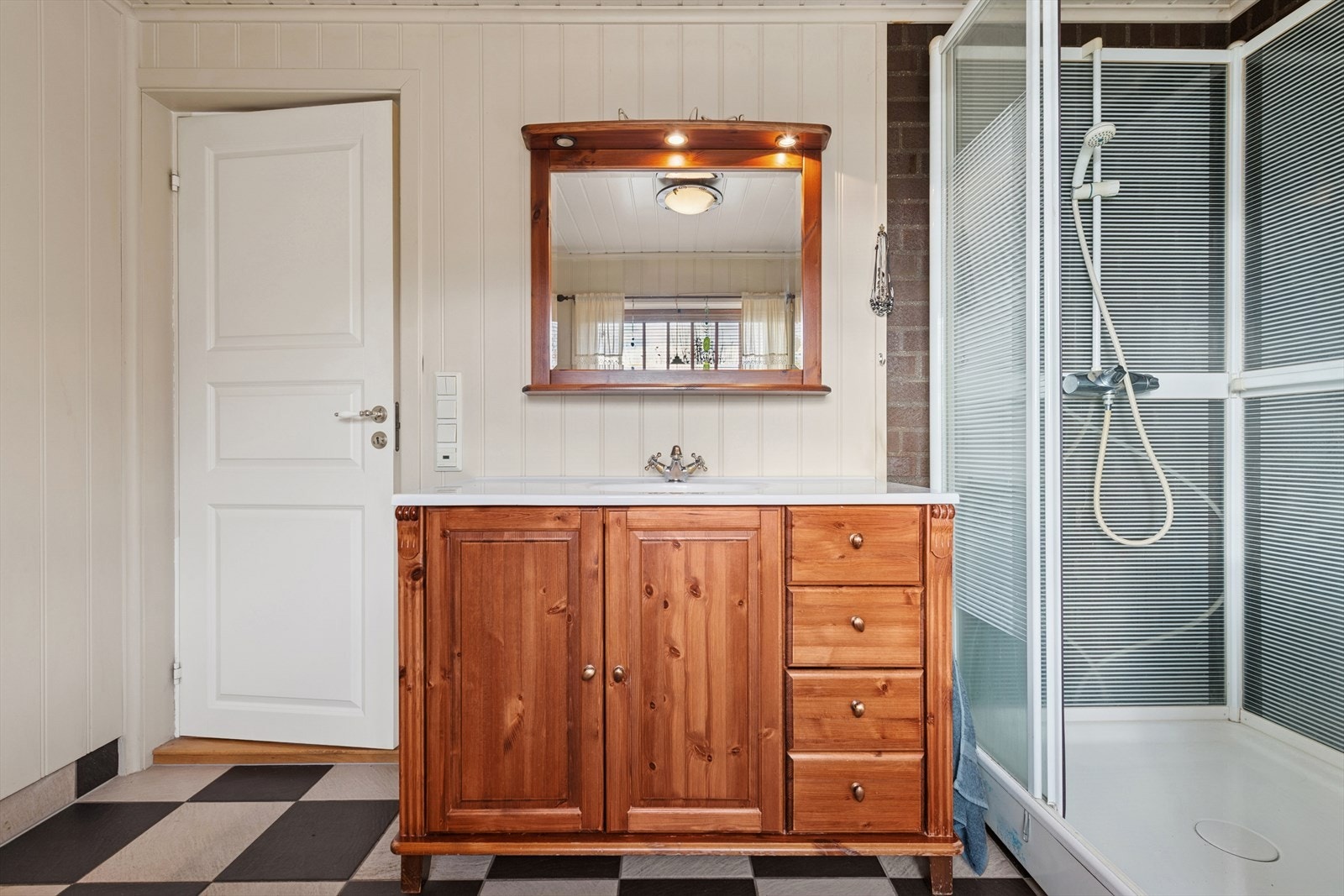 Badet er utstyrt med toalett, dusjkabinett, baderomsinnredning og opplegg til vaskemaskin. Galleribilde