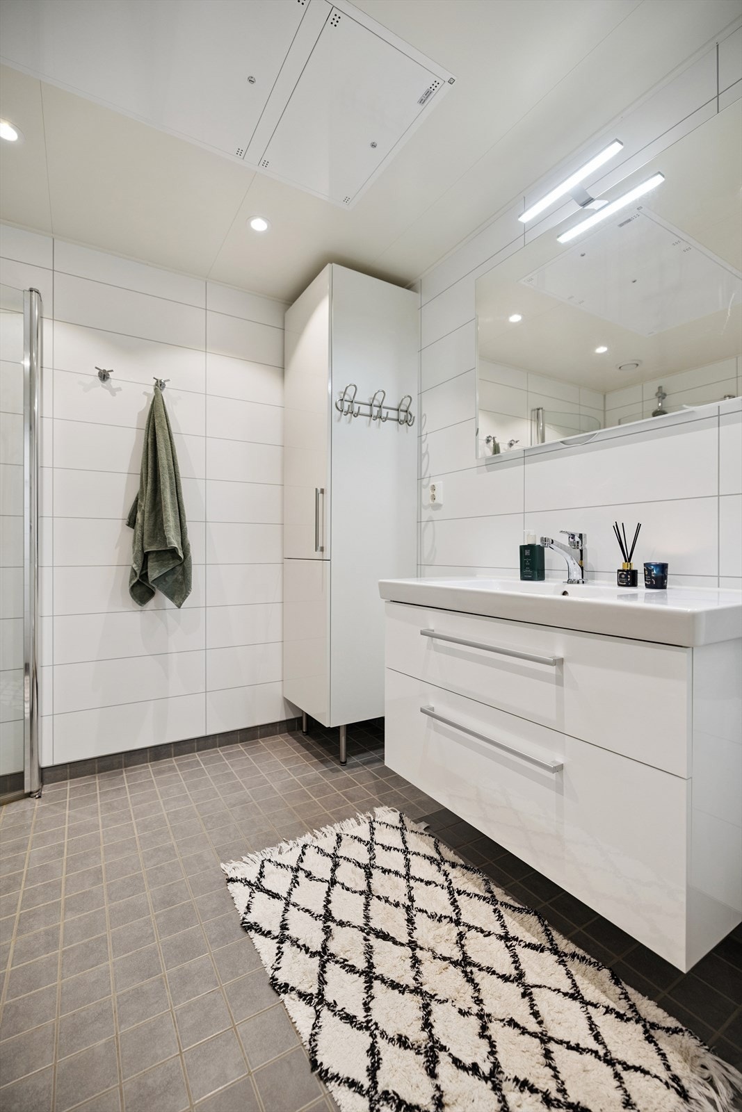 Stilren baderomsinnredning med heldekkende servant og god oppbevaringsplass. Galleribilde