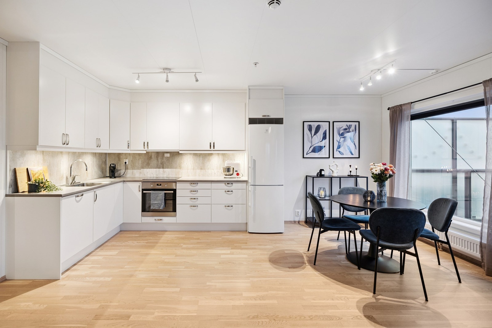 Et lyst og funksjonelt kjøkken i åpen løsning mot stuen. Galleribilde