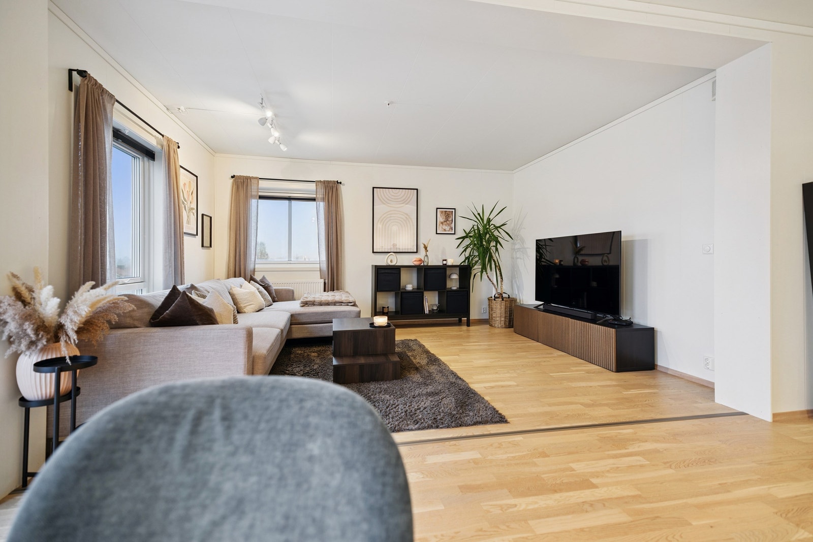 Stuen er et lyst og luftig rom med store vindusflater og gjennomgående parkettgulv. Galleribilde