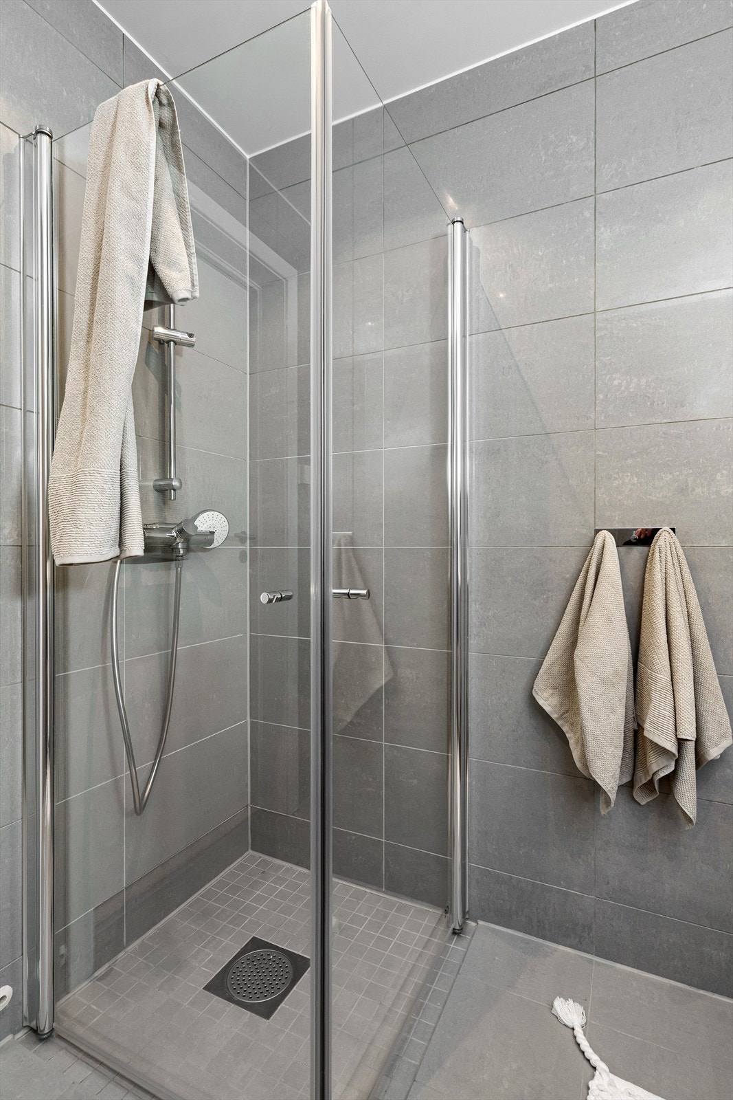 Her finner du veggmontert toalett, baderomsinnredning, dusjhjørne og opplegg for vaskemaskin. Galleribilde