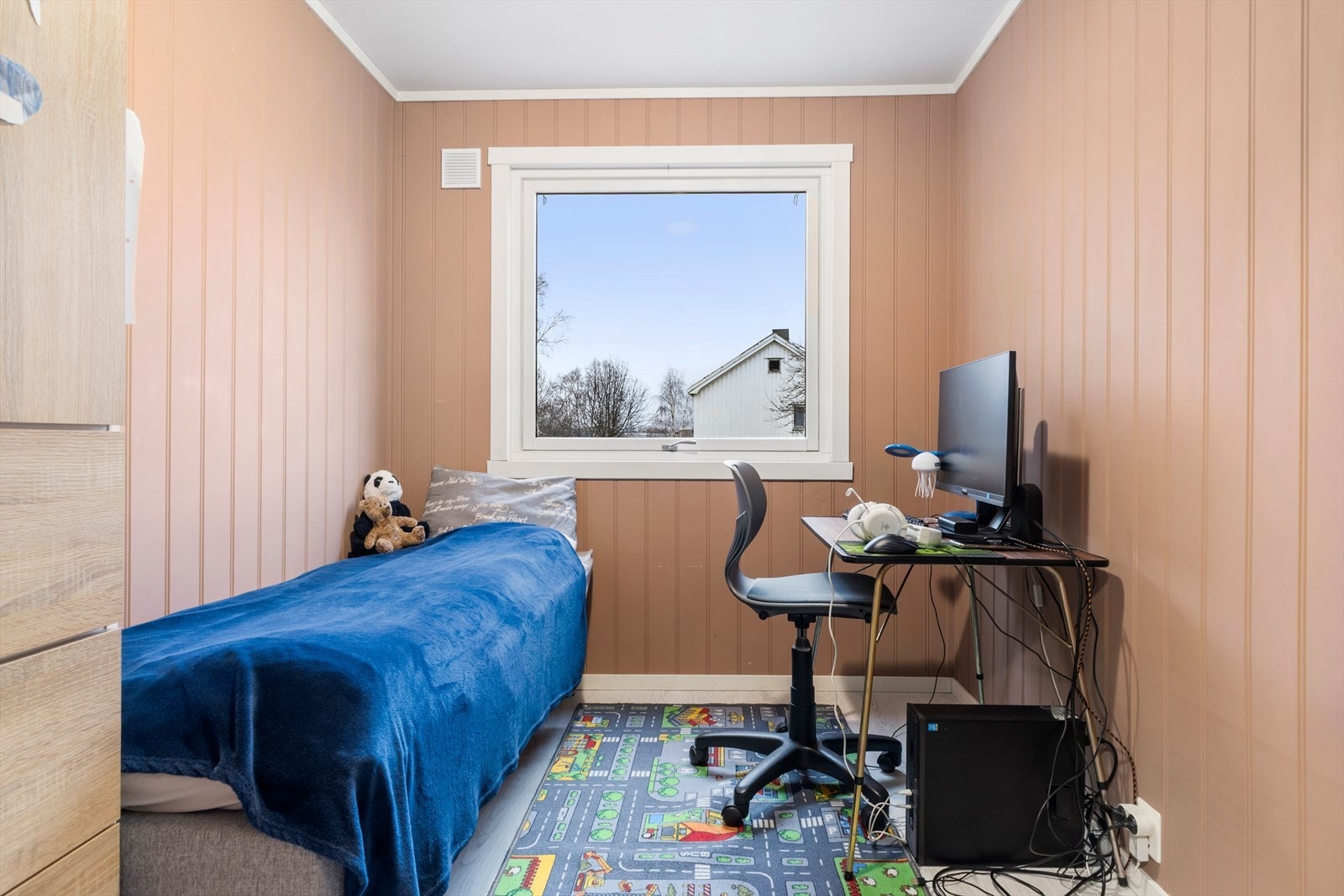 Leilighetens andre soverom har panelplater på veggene malt i en moderne rustrød farge. Galleribilde