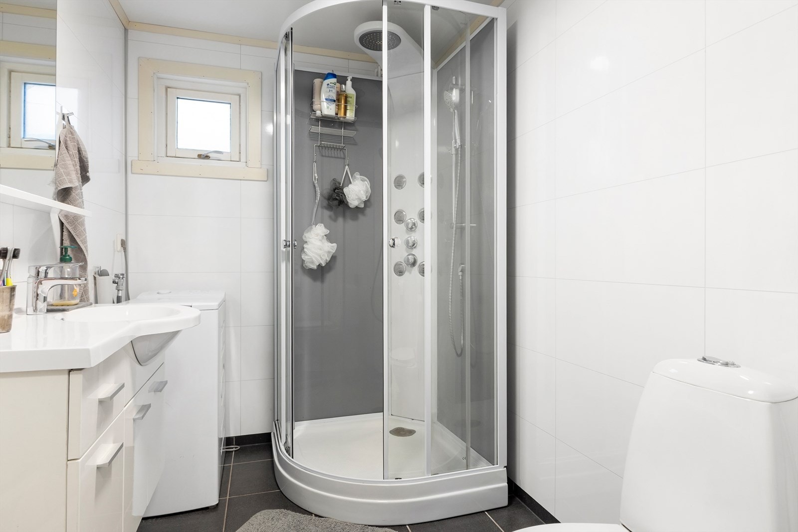 Badet har flislagte gulv med varmekabler. De lyse våtromsplatene gir et rent og delikat uttrykk. Rommet er praktisk innredet, og plassen er godt utnyttet. Galleribilde