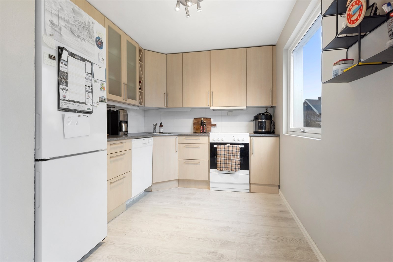 Kjøkkenet er utstyrt med frittstående hvitevarer som kjøleskap, oppvaskmaskin og komfyr med koketopp. Galleribilde