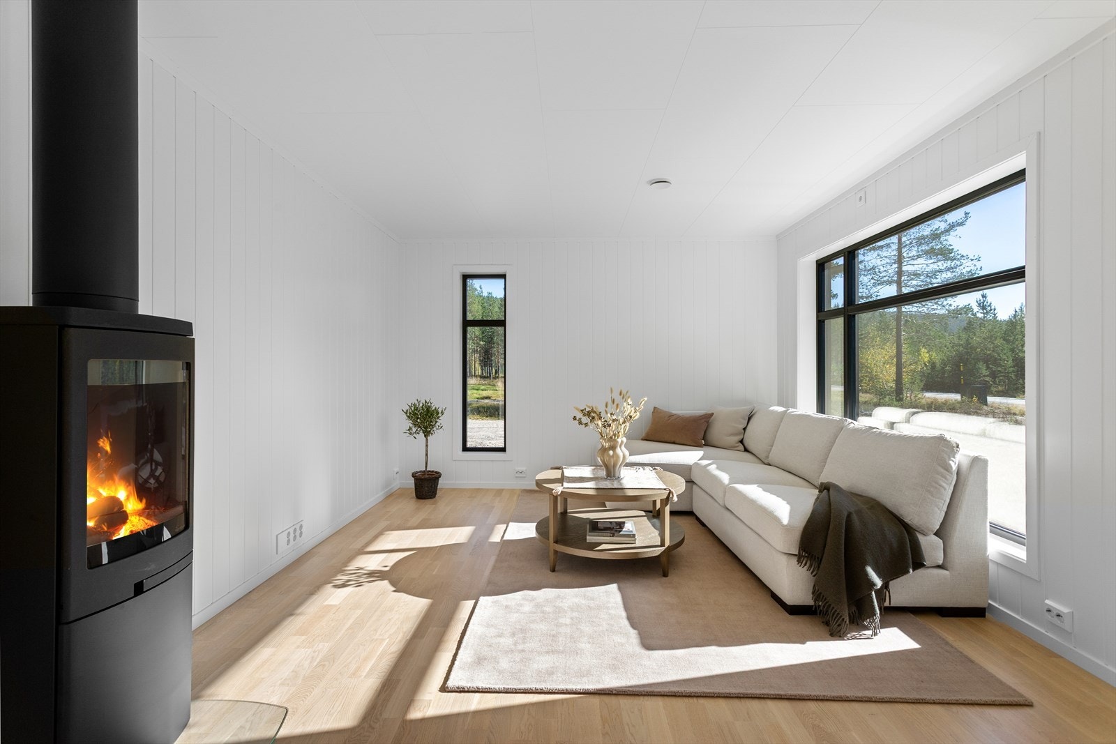 Blikkfanget i stuen er den stemningsfulle vedovnen som skaper god varme til etasjen. Galleribilde