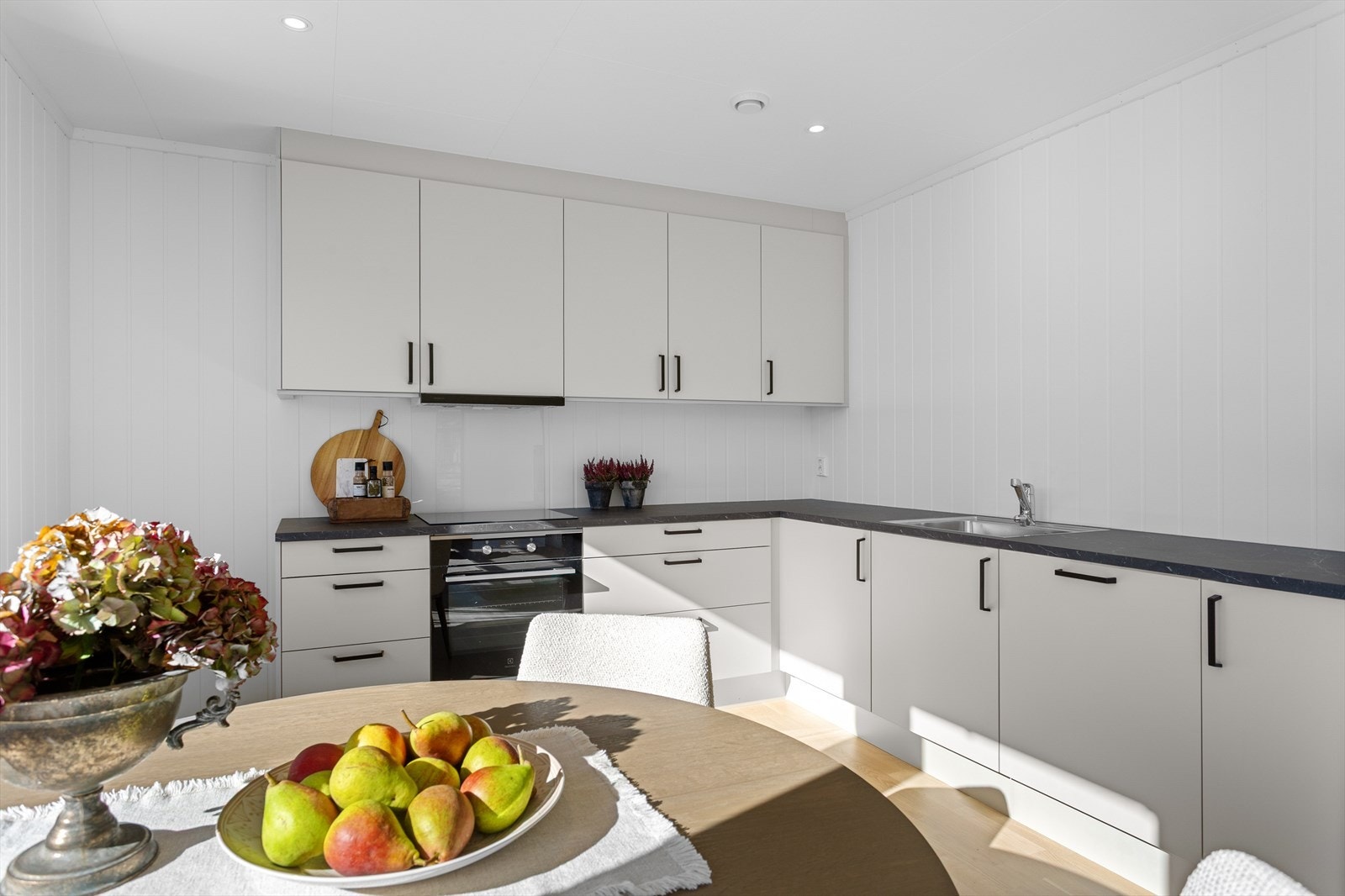 Delikat og moderne kjøkkeninnredning fra Sigdal med lyse slette fronter og benkeplate av laminat. Galleribilde