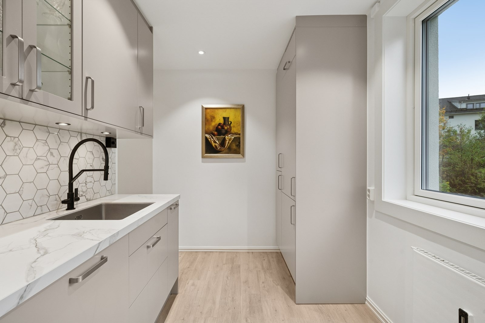 Innredningen har glatte fronter og enkelte glassfronter i overskapene, supplert med belysning under overskapene. Galleribilde