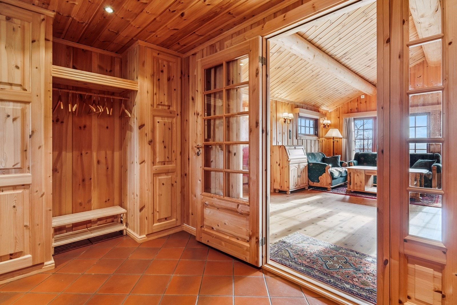 Fra det overbygde inngangspartiet kommer du inn i romslig entré med plass til garderobeskap for oppbevaring av sko og ytterklær på en praktisk måte. Galleribilde