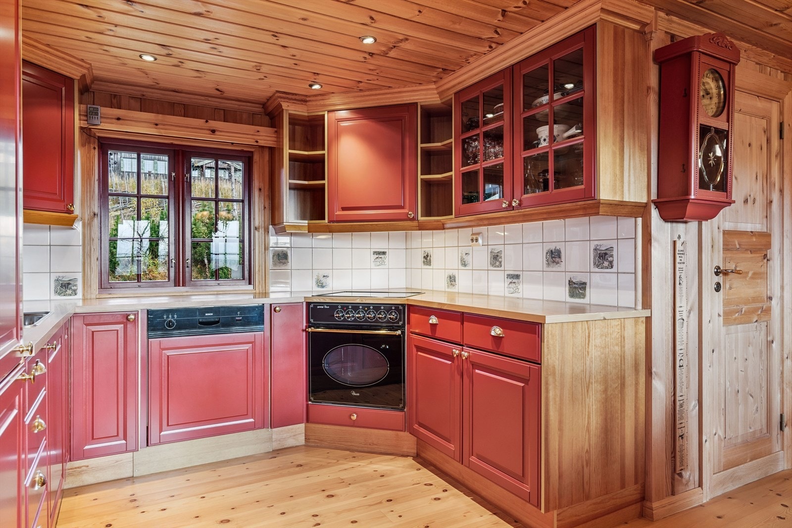 innredningen er i klassisk hyttestil med profilerte fronter, enkelte med glassfelt, og benkeplate i laminat med nedfelt oppvaskkum av rustfritt stål. Galleribilde