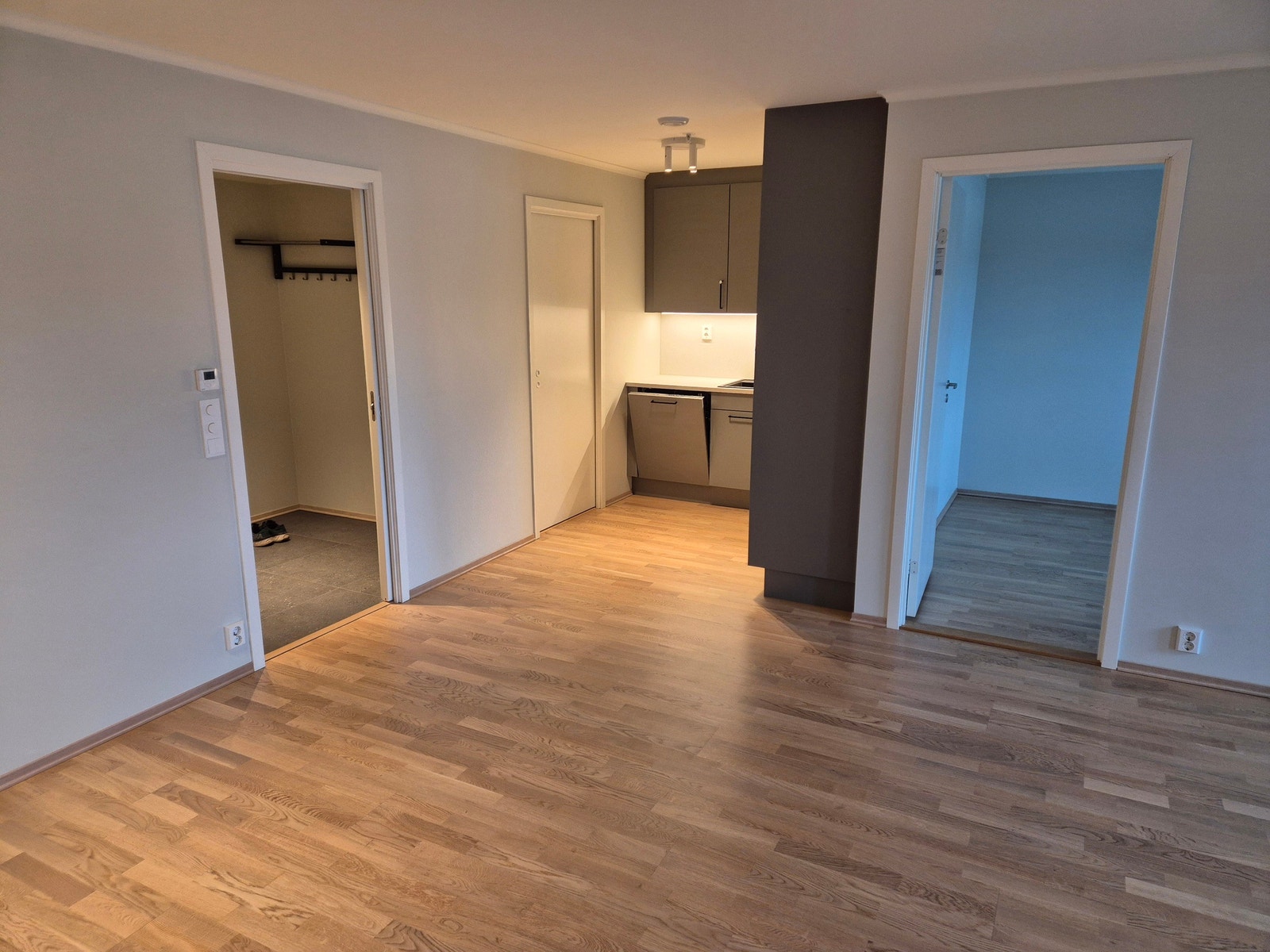 Stuen er delvis avskjermet fra kjøkkenkroken Galleribilde