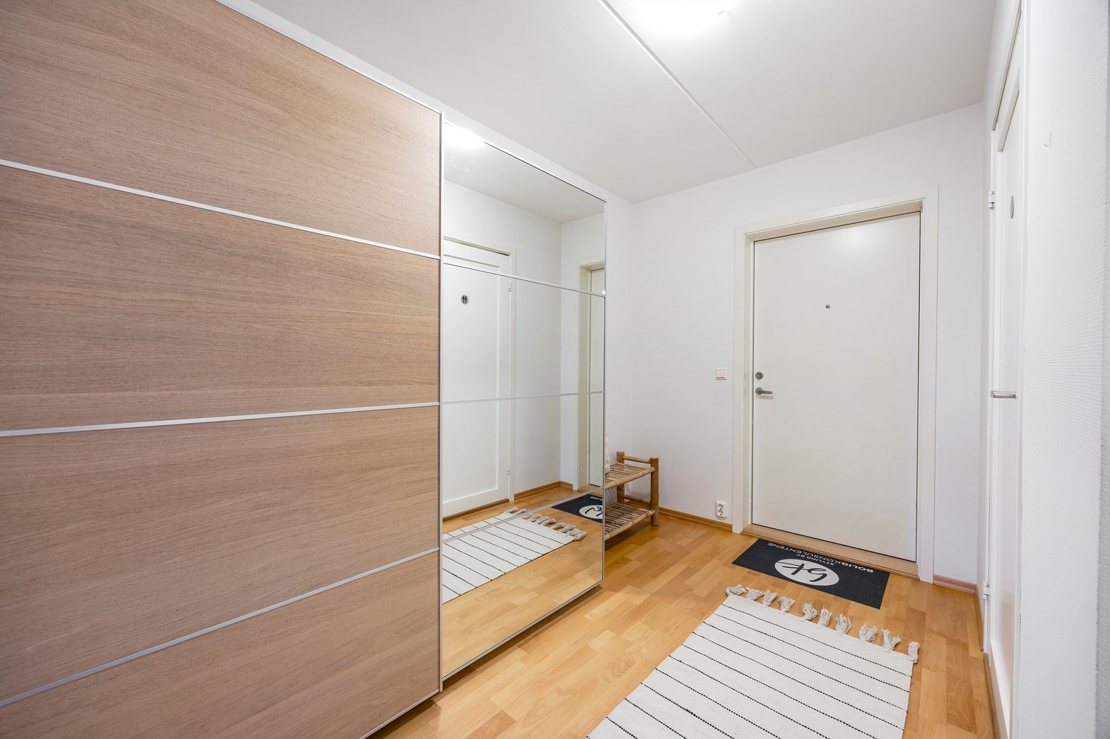 Romslig entré med gode oppbevaringsmuligheter i en stor skyvedørsgarderobe. Galleribilde