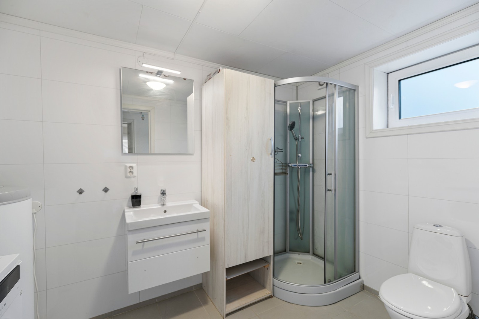 Bad fra 2018 med toalett, dusjkabinett, servantinnredning og opplegg for vaskemaskin Galleribilde