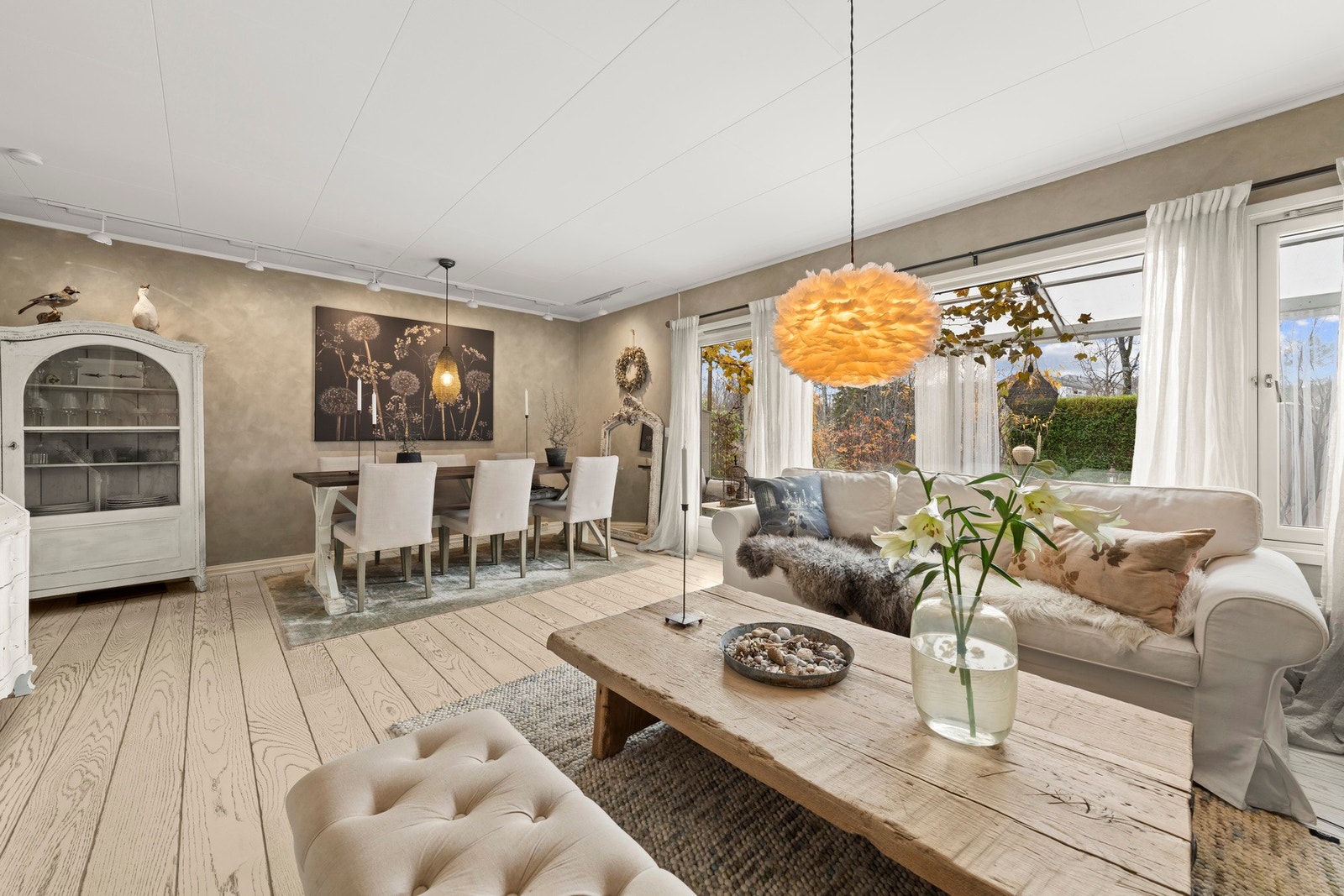 Den romslige stuen gir plass til en koselig sofakrok med store vindusflater som gir flott utsyn mot grønne omgivelser. Galleribilde