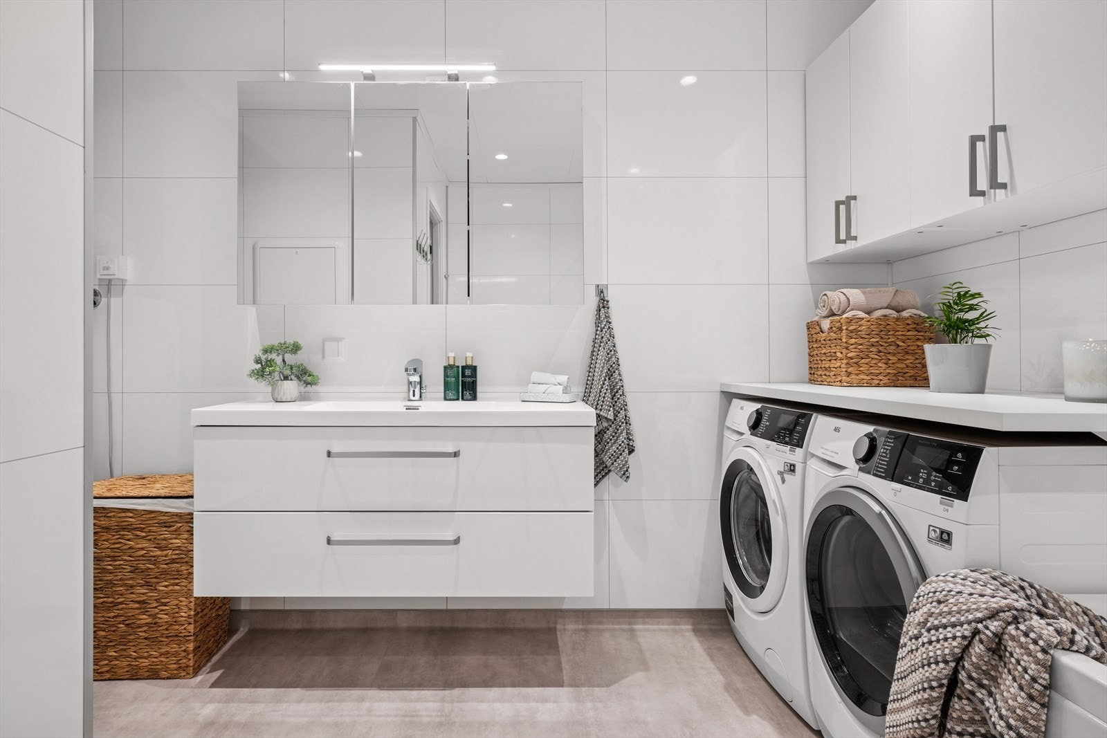 Lyst og pent bad med moderne baderomsinnredning med gode skuffer, servant og speilskap med belysning. Galleribilde