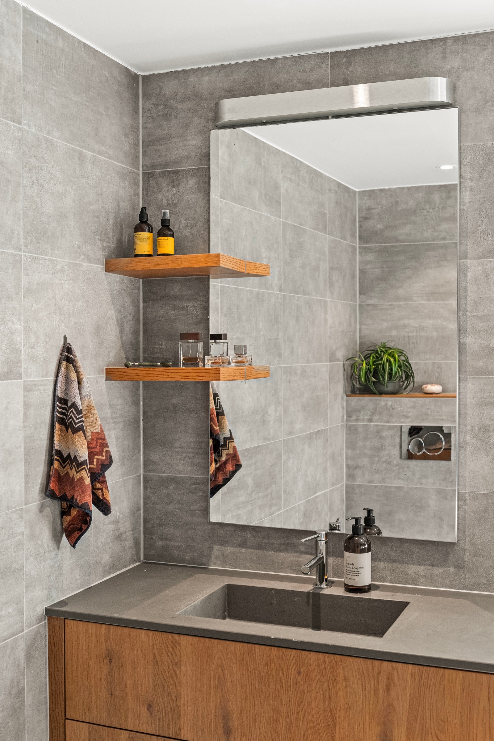 Badet er utstyrt med dusj, servant med underskap og vegghengt toalett, noe som gir et moderne og ryddig uttrykk. Galleribilde