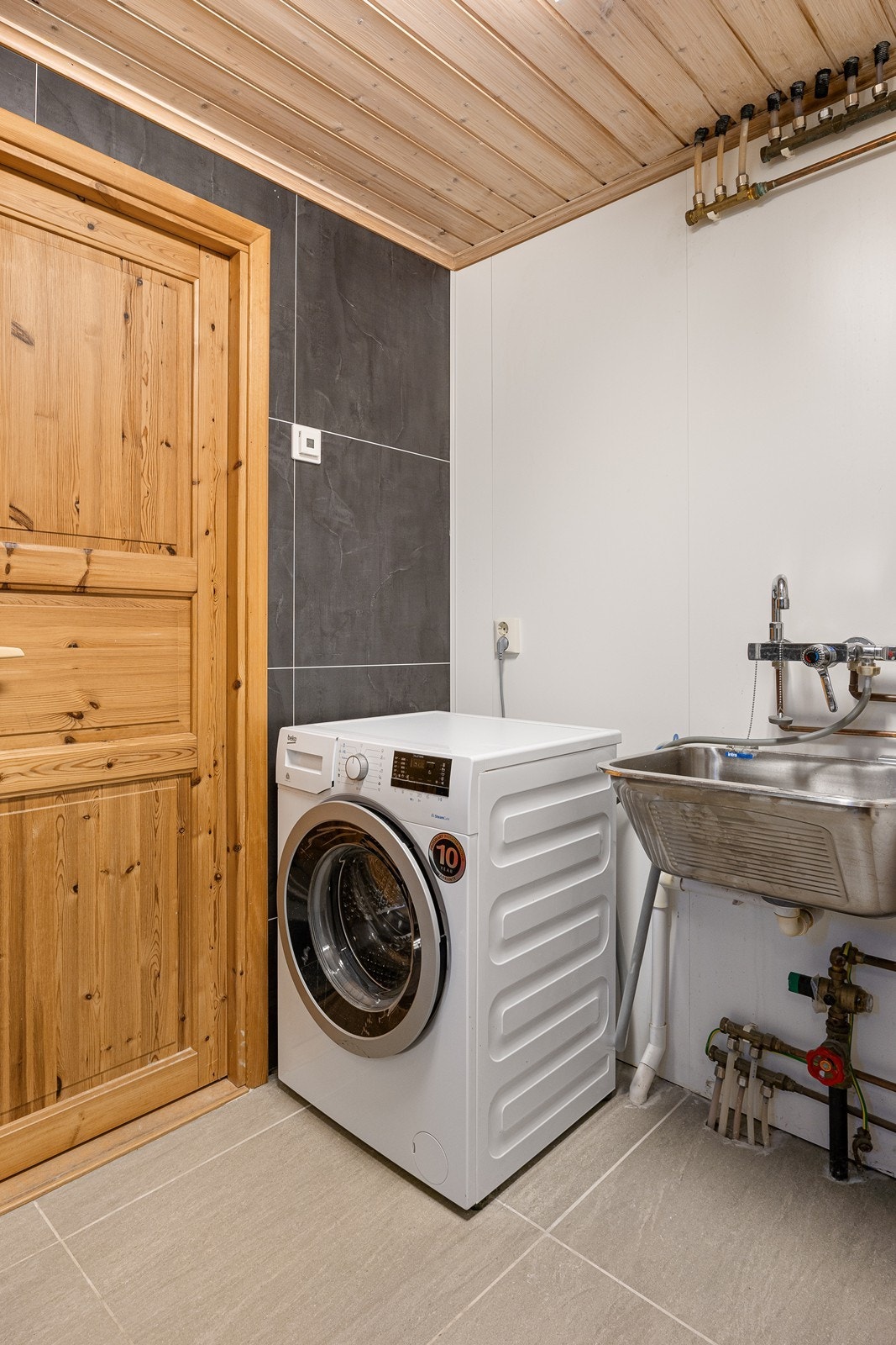 Vaskeromsdelen har skyllekum og opplegg for vaskemaskin. Galleribilde