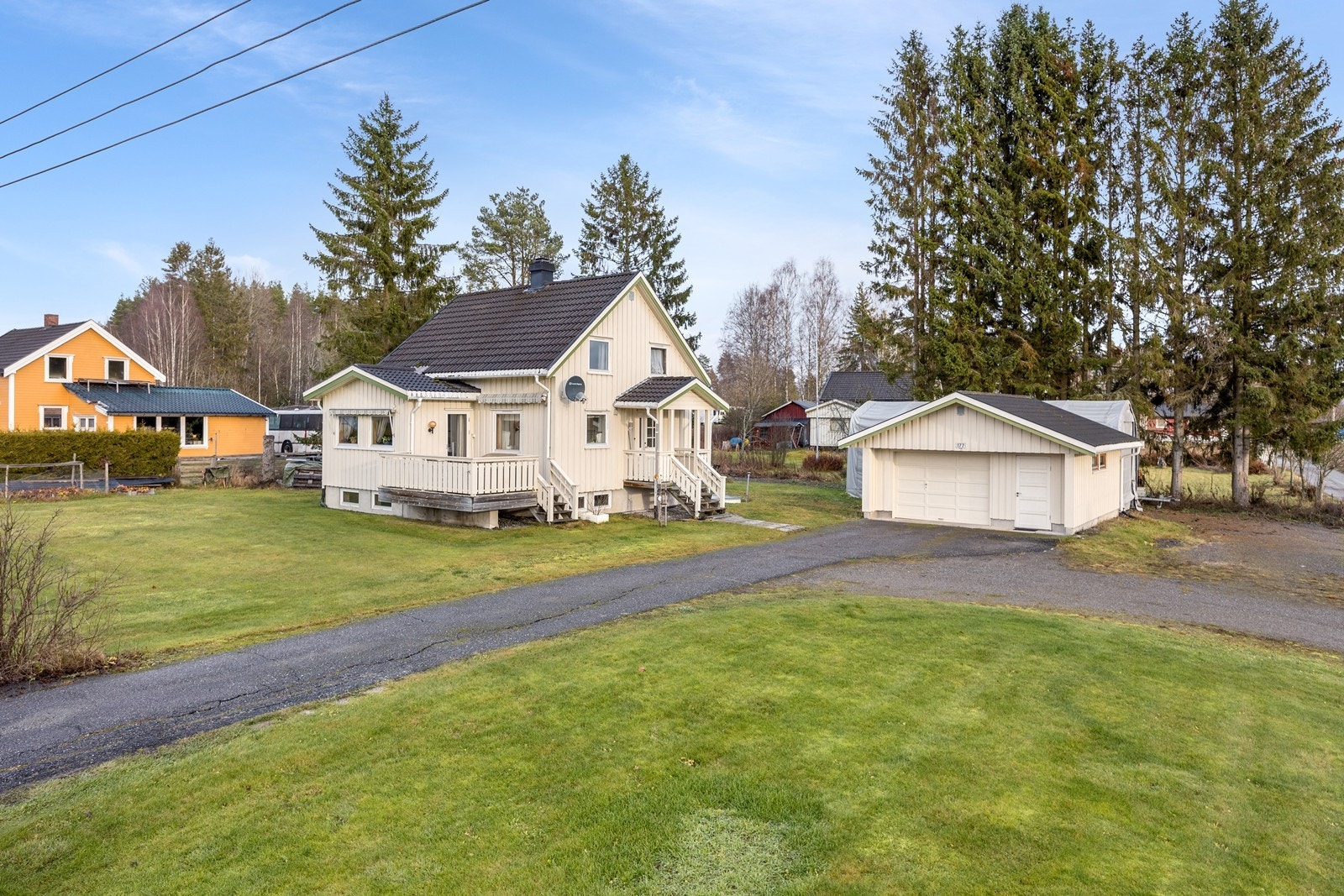 Parkering kan gjøres på den store, gruslagte gårdsplassen eller i den frittliggende garasjen som har et areal på ca. 34 kvm - denne har el-billader. Galleribilde