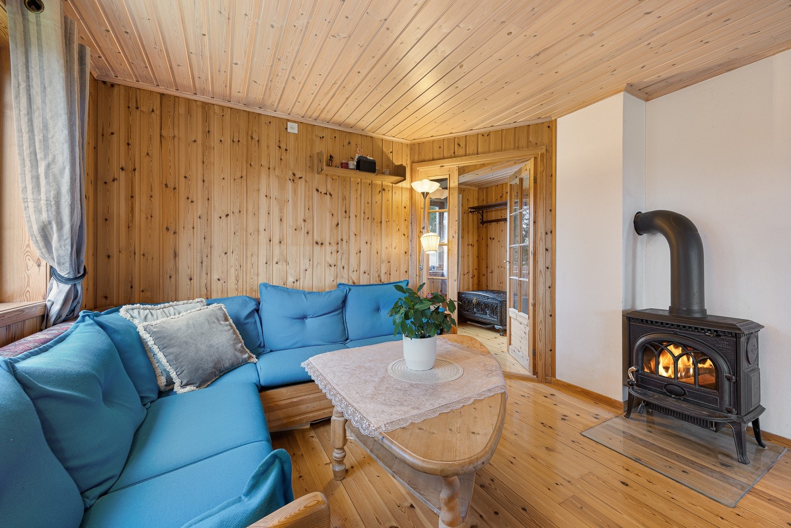 Foran en hvitmalt murvegg bidrar en god peisovn til ekstra hygge og varme. Galleribilde