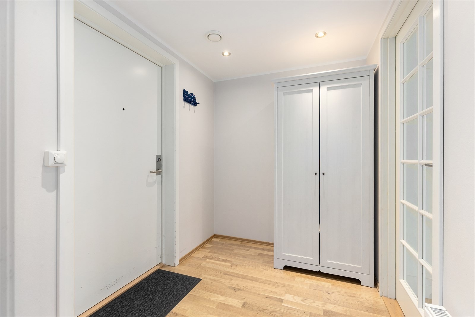 Lys og romslig entré med god plass til oppbevaring av sko- og yttertøy i romslig garderobeskap. Malt tak med innfelte spotter. Galleribilde