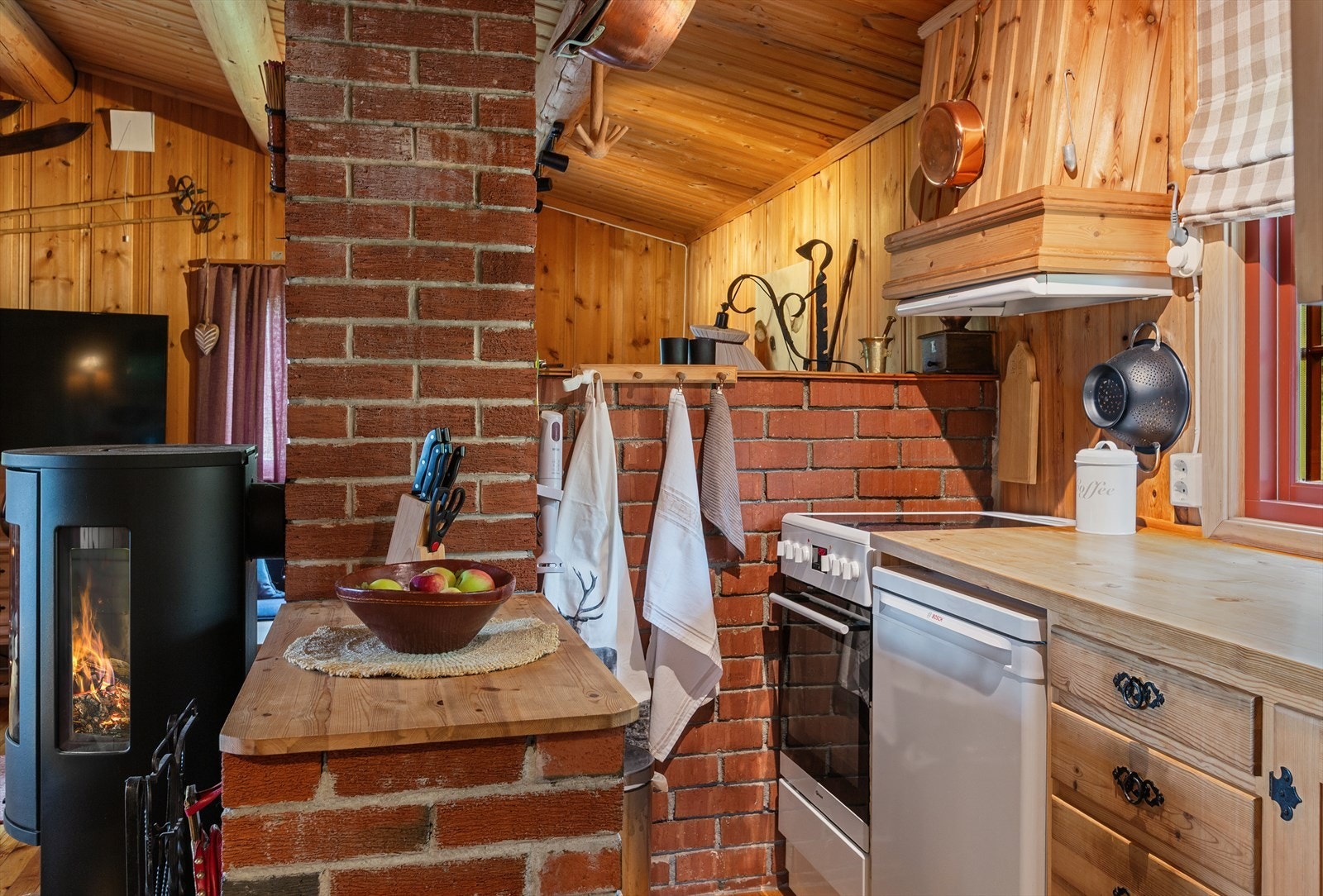 Kjøkkenet har en kjøkkenøy i teglstein i forlengelsen mot pipen. Galleribilde